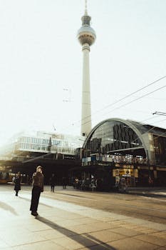 A view of Berlin's iconic TV tower and a tram at Alexanderplatz during golden hour.