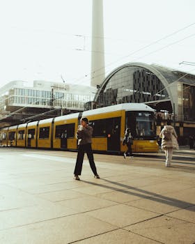 Golden hour view of a yellow tram passing by Alexanderplatz in Berlin.