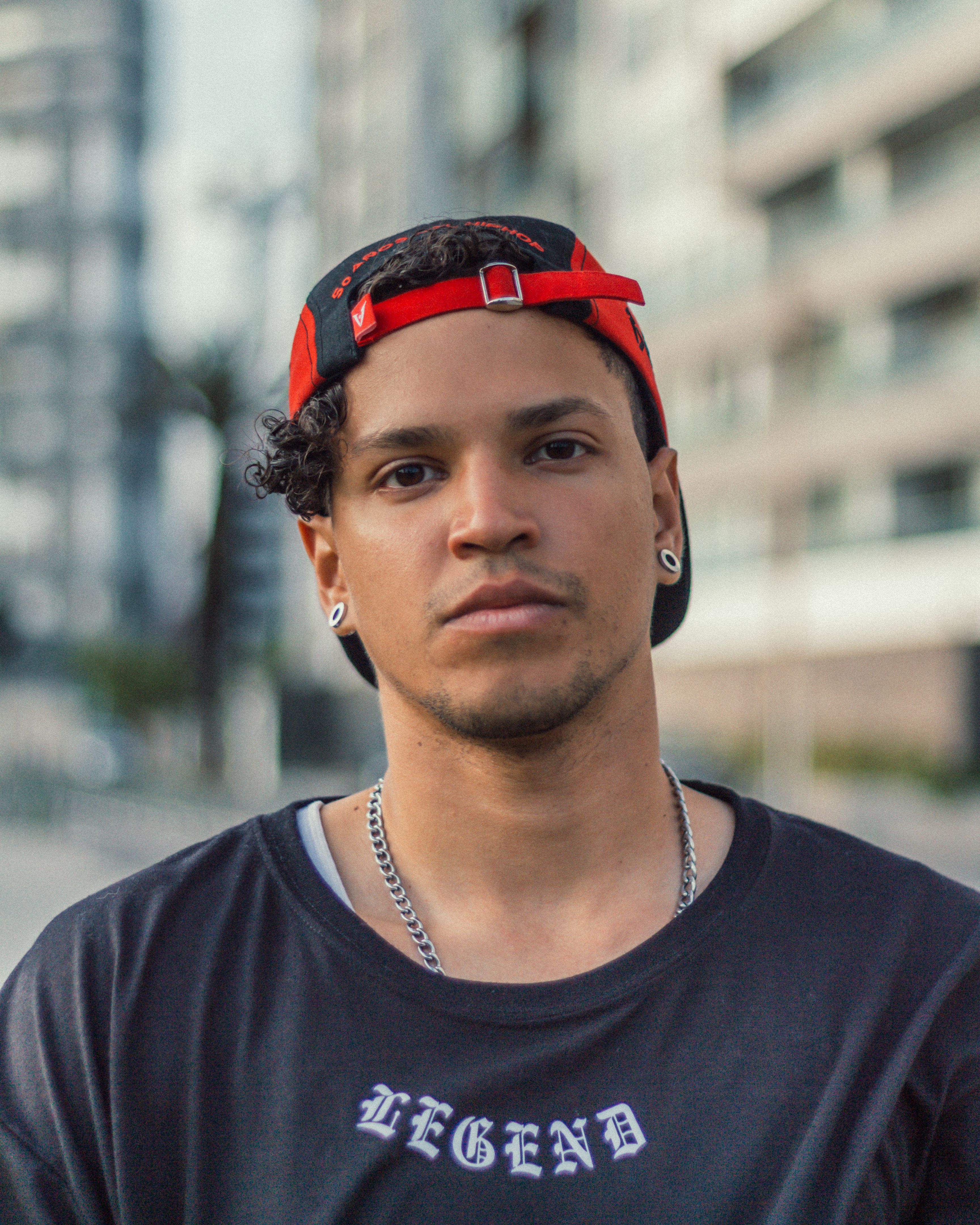 Portrait of a confident young man in a modern urban setting wearing casual streetwear.
