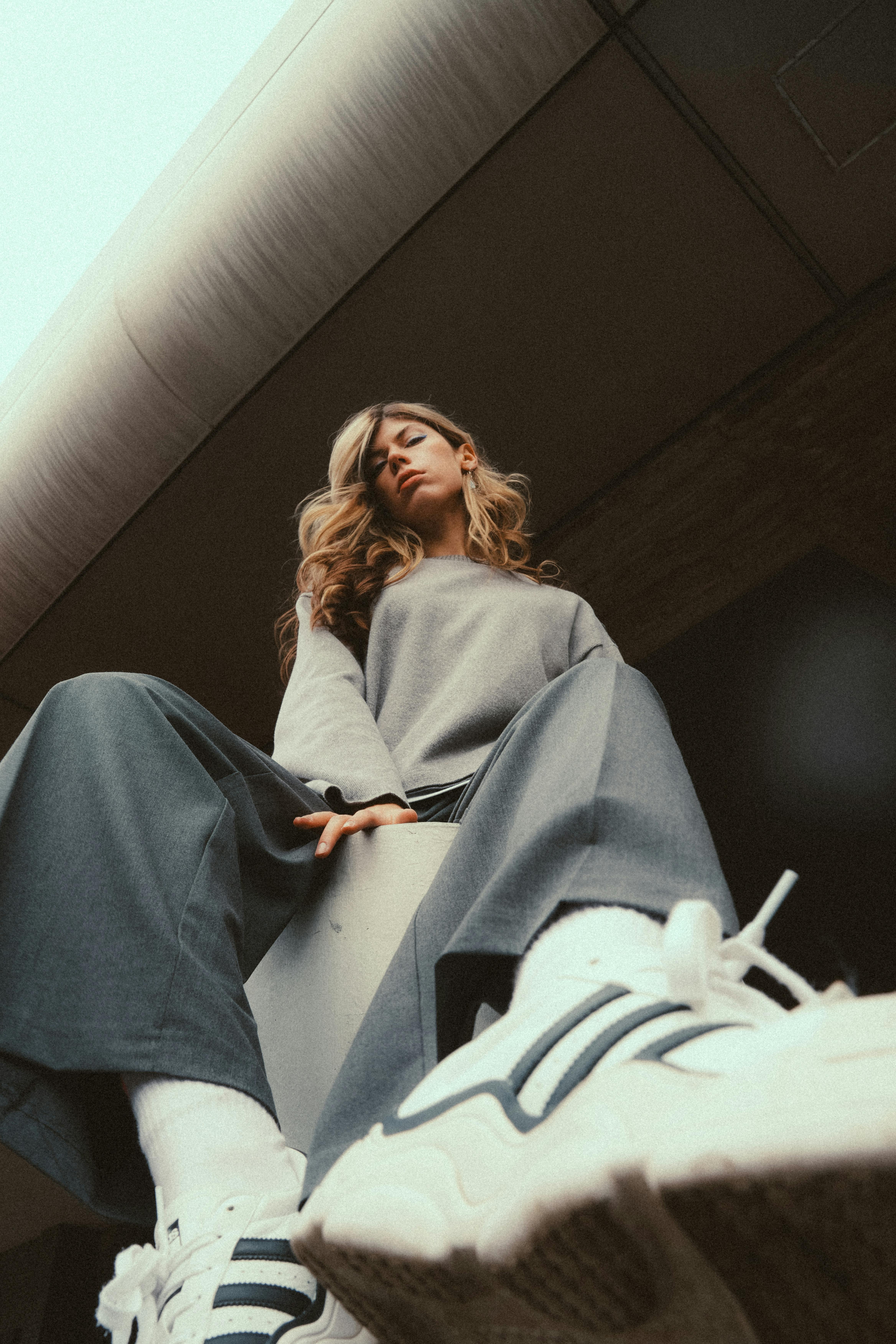 A modern perspective shot of a woman in casual streetwear posing confidently in an urban environment.