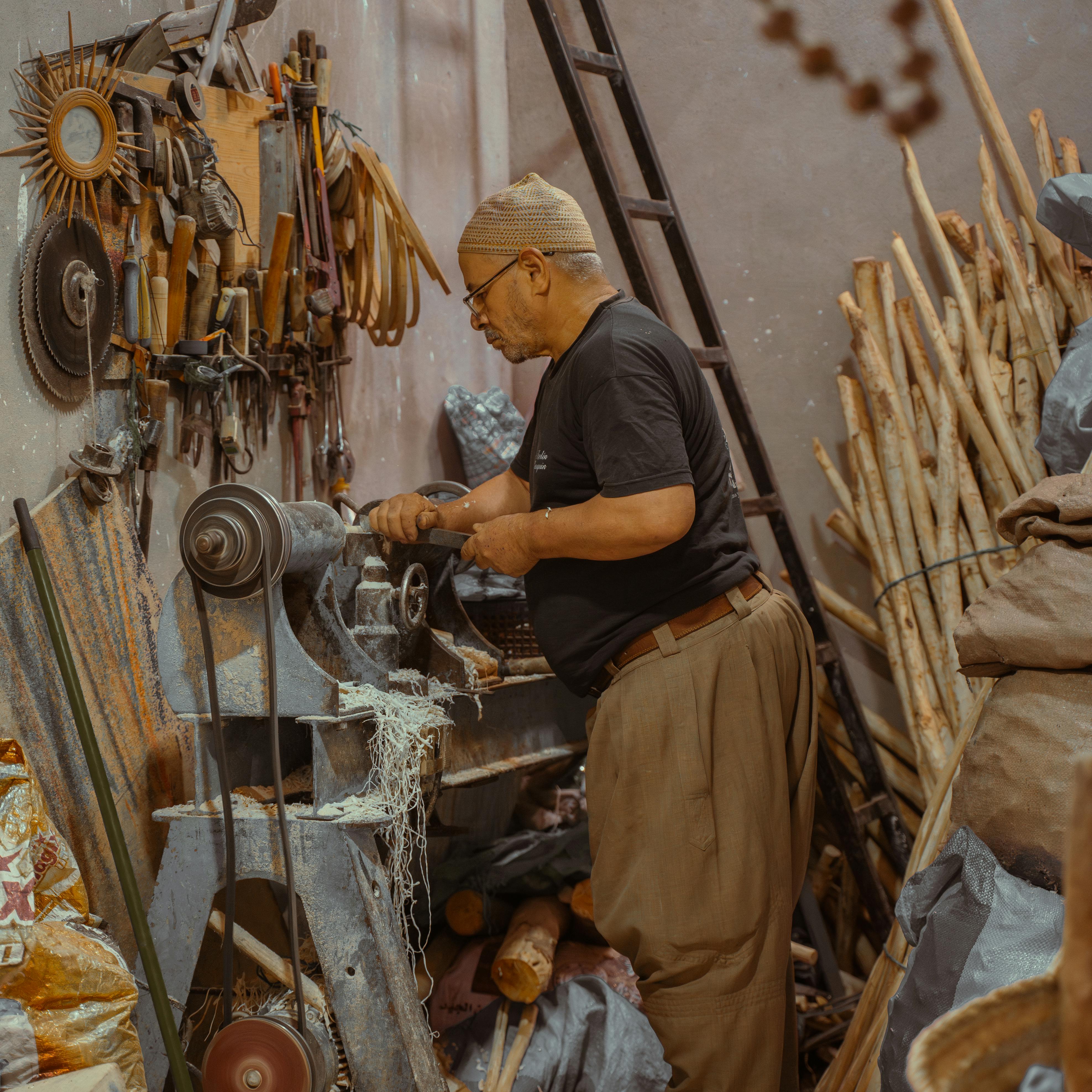 Artisan at work using tools in a traditional Marrakech workshop.