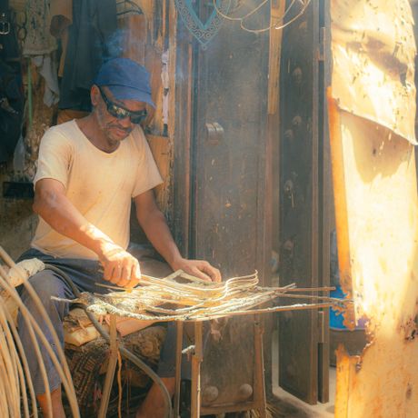 Craftsman drawing reeds in a sunlit workshop — Salaheddine Es-sellak on Pexels