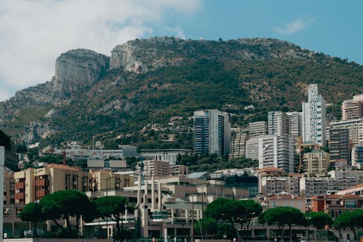 Explore the stunning skyline of Monte Carlo nestled against a majestic mountain backdrop, captured in summer.