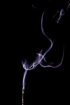 Ethereal purple smoke rising gracefully against a black background.