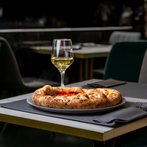 Free A tempting pizza and glass of white wine on a restaurant patio table, ideal for food enthusiasts. Stock Photo