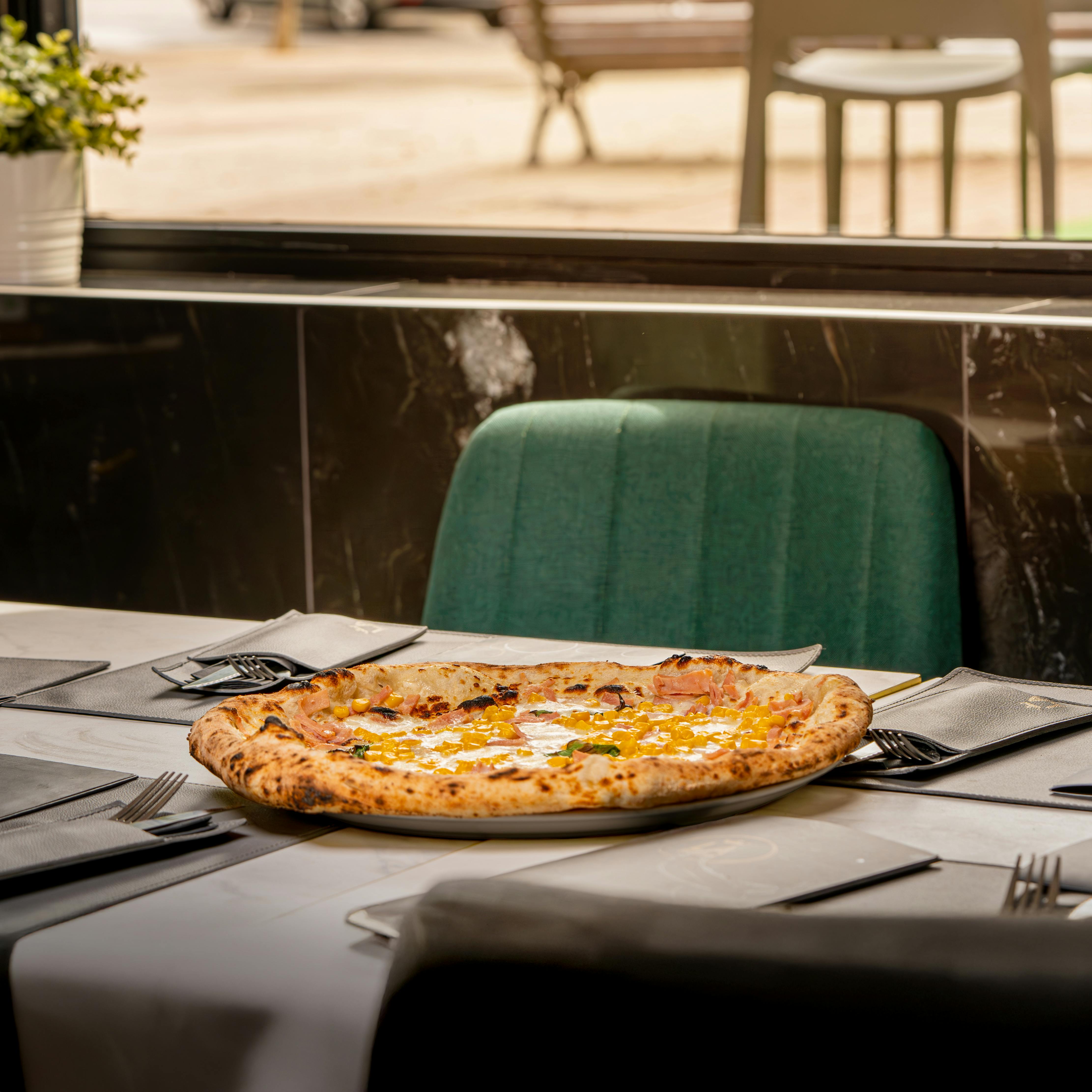 A freshly baked pepperoni pizza served in a cozy, modern cafe with ample seating.