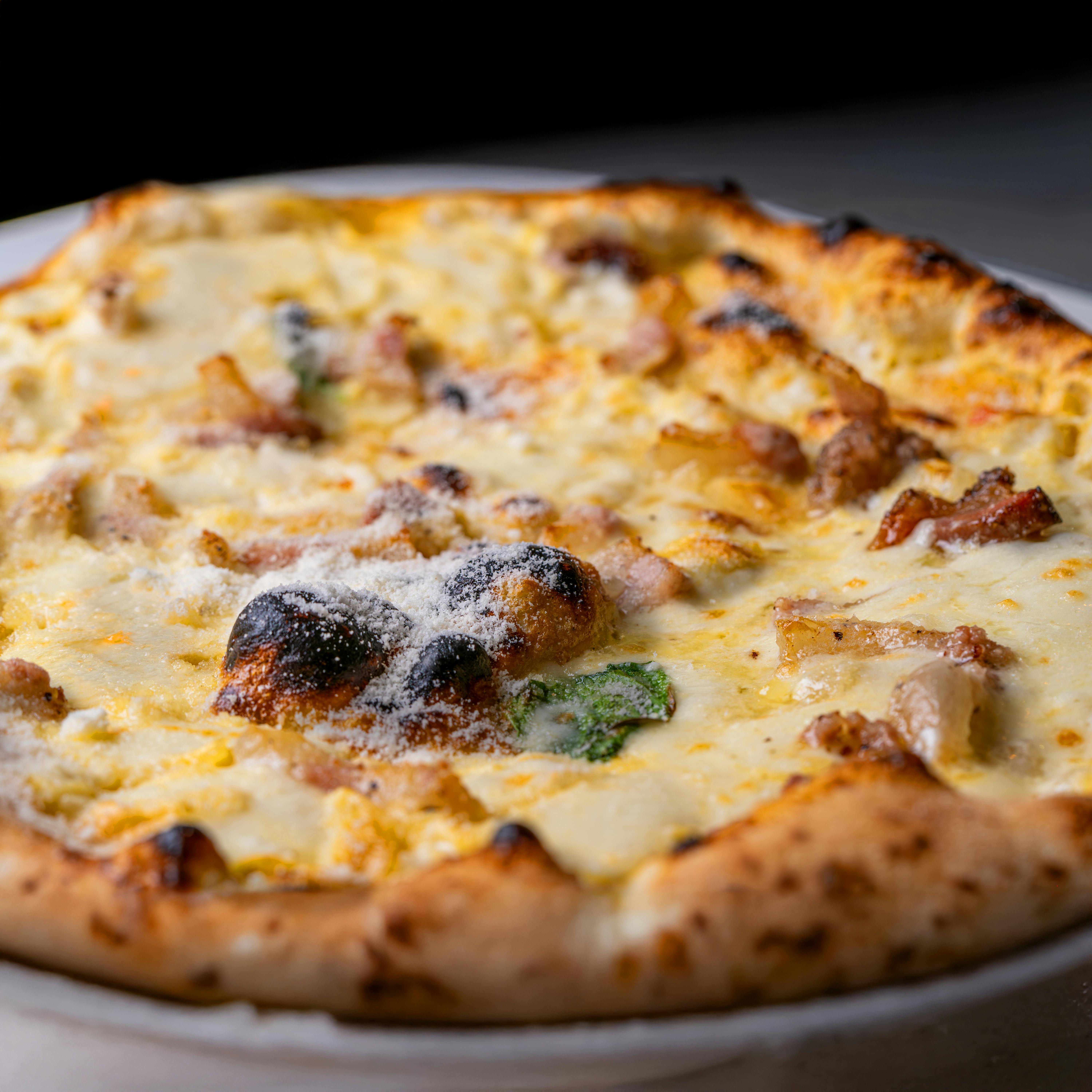 Mouth-watering close-up of a cheese pizza with savory toppings and golden crust.