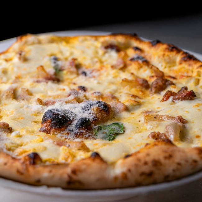 Mouth-watering close-up of a cheese pizza with savory toppings and golden crust.
