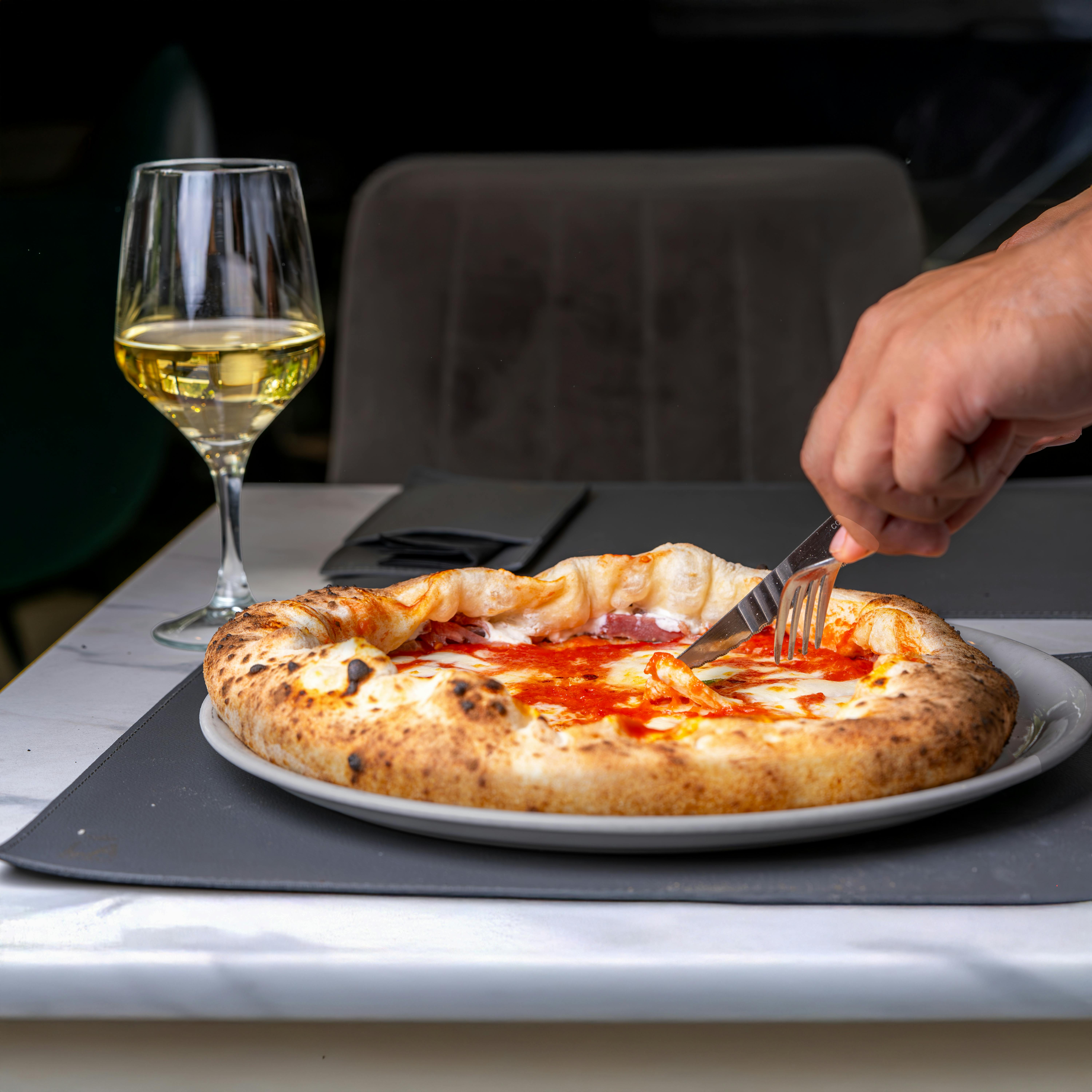 Close-up of Neapolitan pizza and wine, perfect for food and dining concepts.