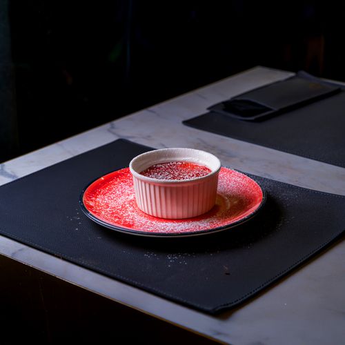 Free A served ramekin with red sauce and powdered sugar on a restaurant table setting. Stock Photo