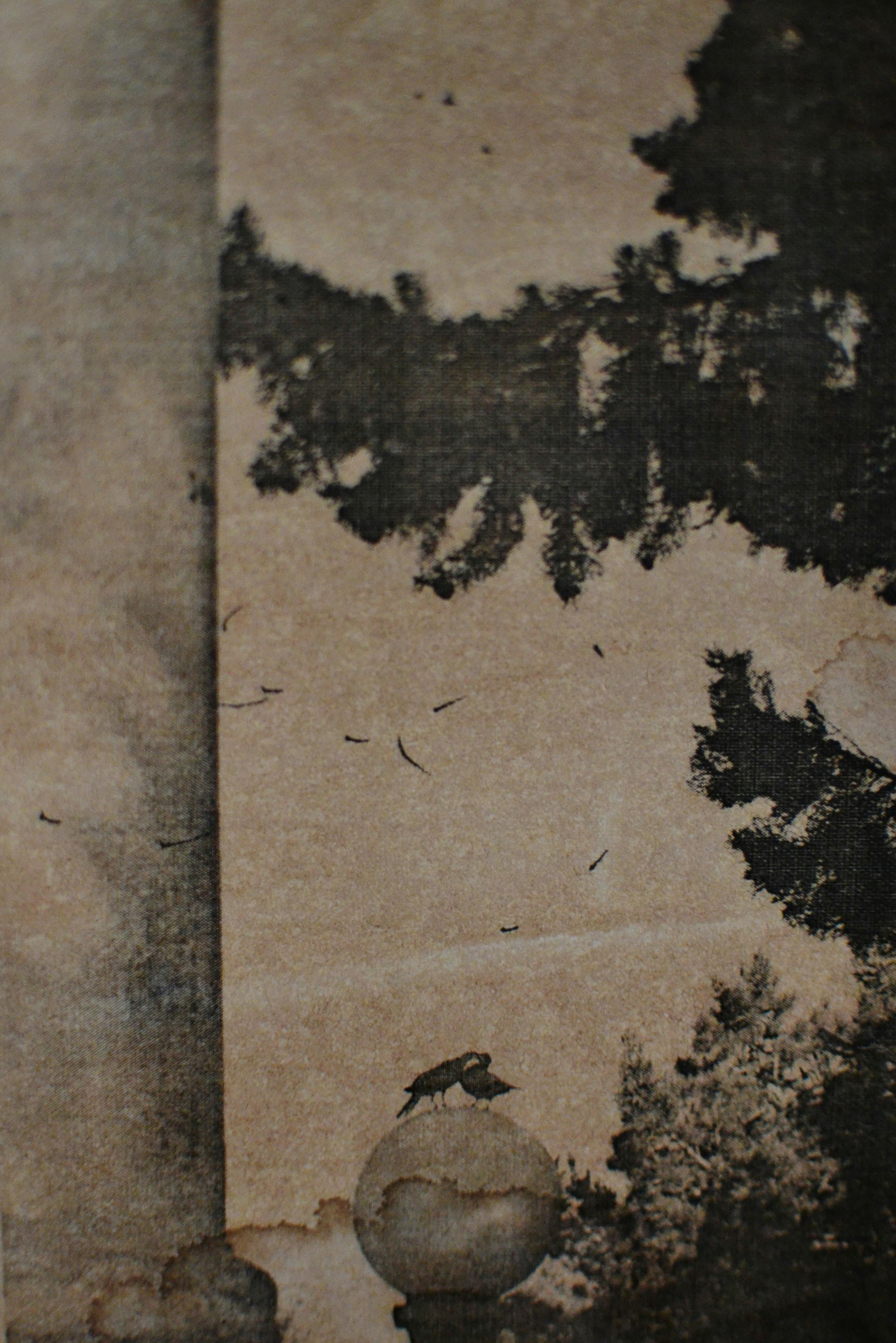 Sepia-toned image of a bird perched on a globe amidst a classic outdoor landscape.