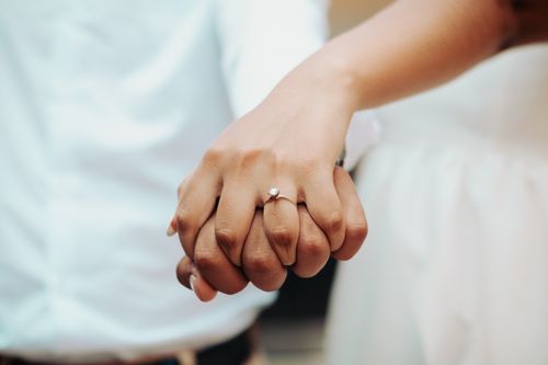 Free Close-up of a couple holding hands showcasing an engagement ring. A symbol of love and commitment. Stock Photo
