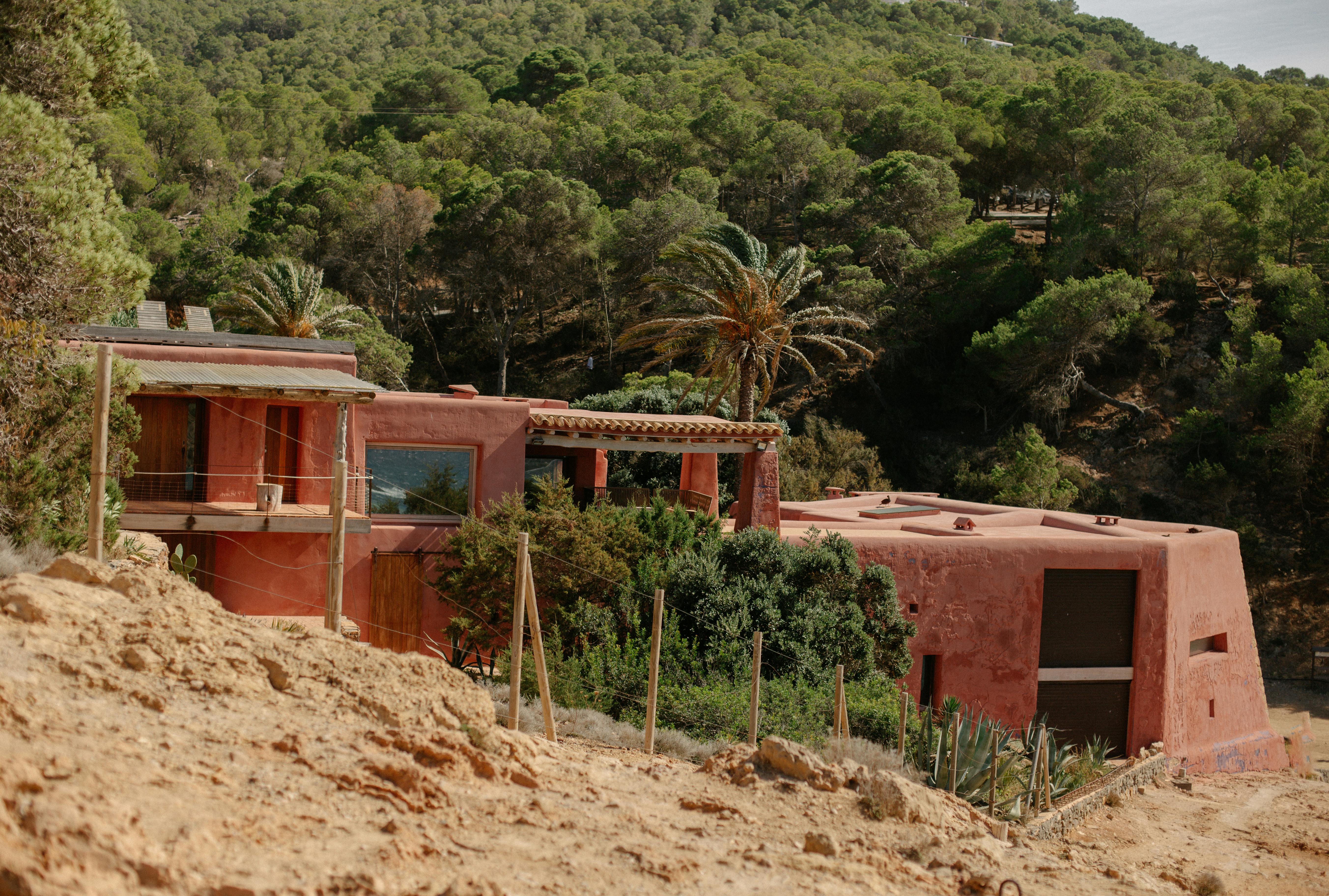 A charming rustic villa nestled in the lush hills of Ibiza, showcasing Mediterranean architecture.
