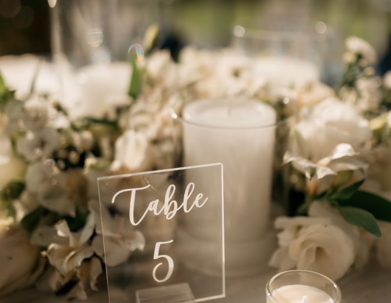 Table setting with candles, white flowers and table number