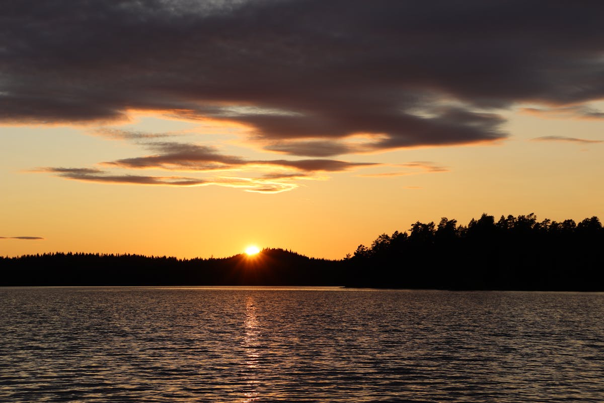 A calm Swedish lake at golden hour — the kind of evening Lake Siljan in Dalarna offers through summer