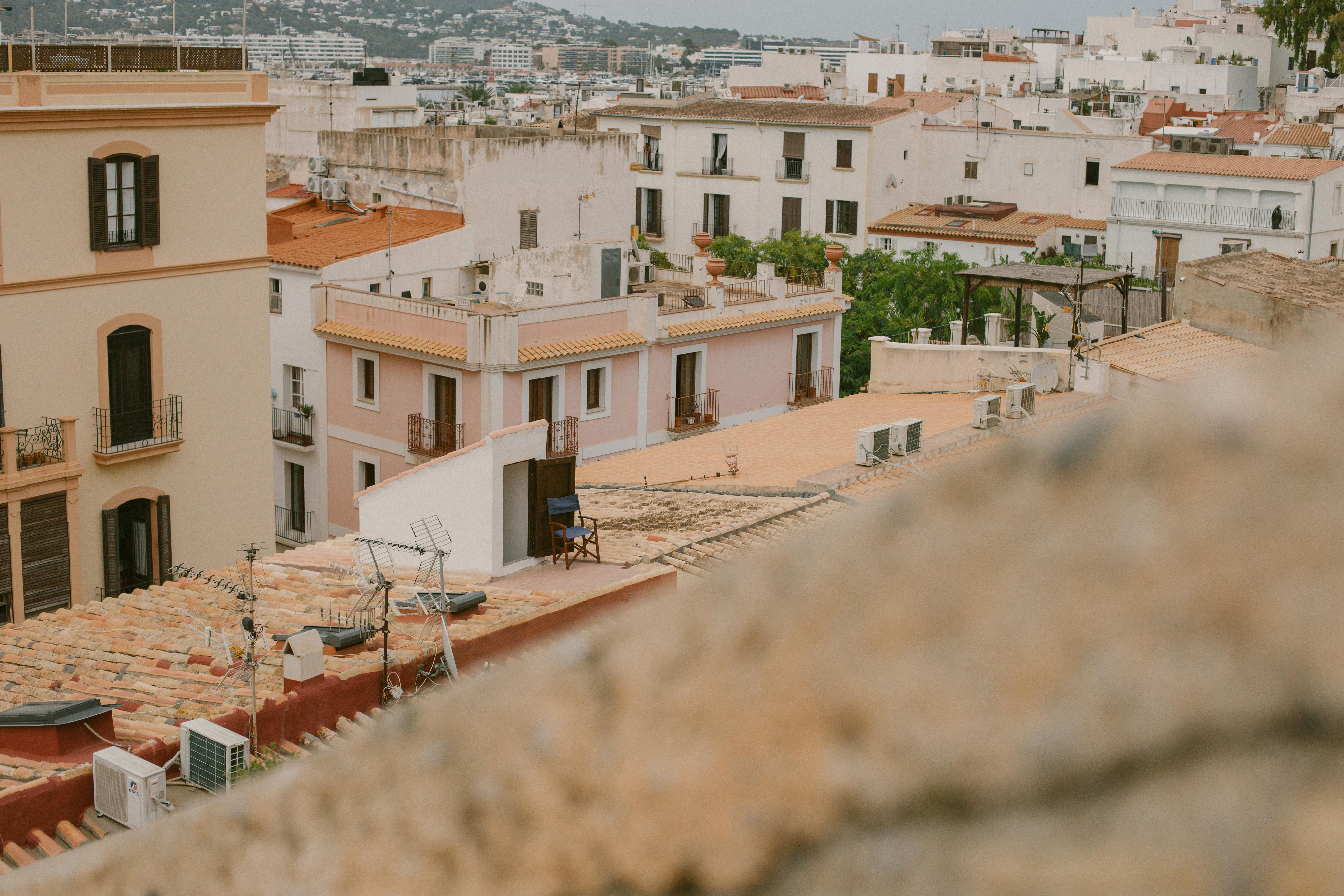 Explore the rustic charm and Mediterranean style of Ibiza City's rooftops with this scenic view.