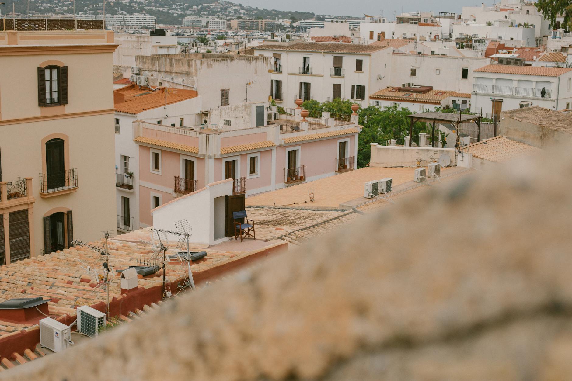 Explore the rustic charm and Mediterranean style of Ibiza City's rooftops with this scenic view.