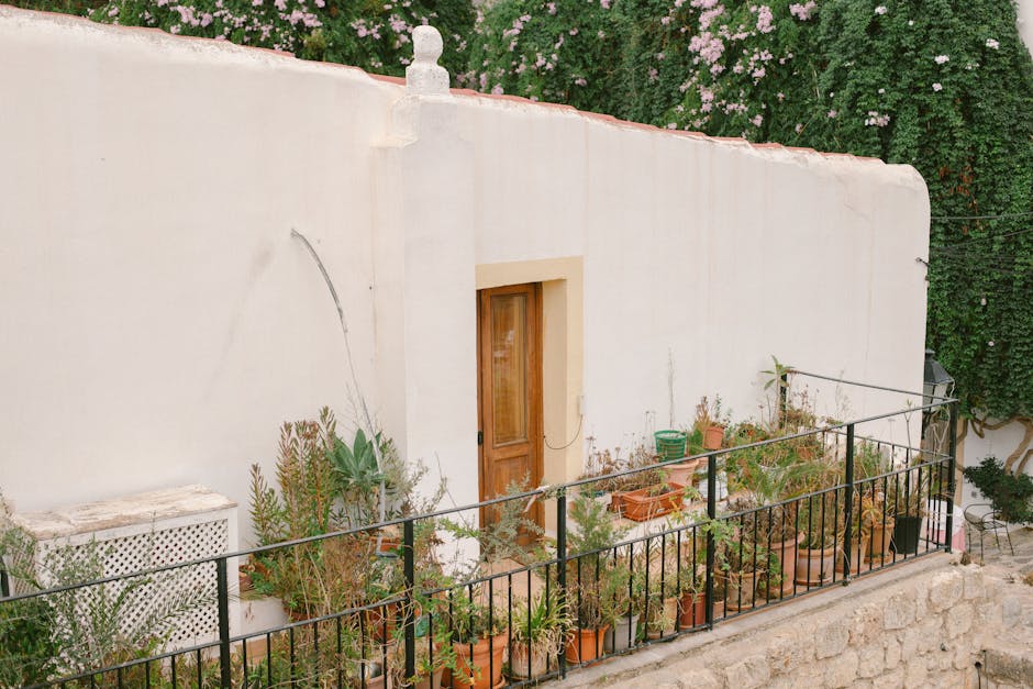 Picturesque Ibiza house with a lush balcony garden, showcasing Mediterranean architecture.