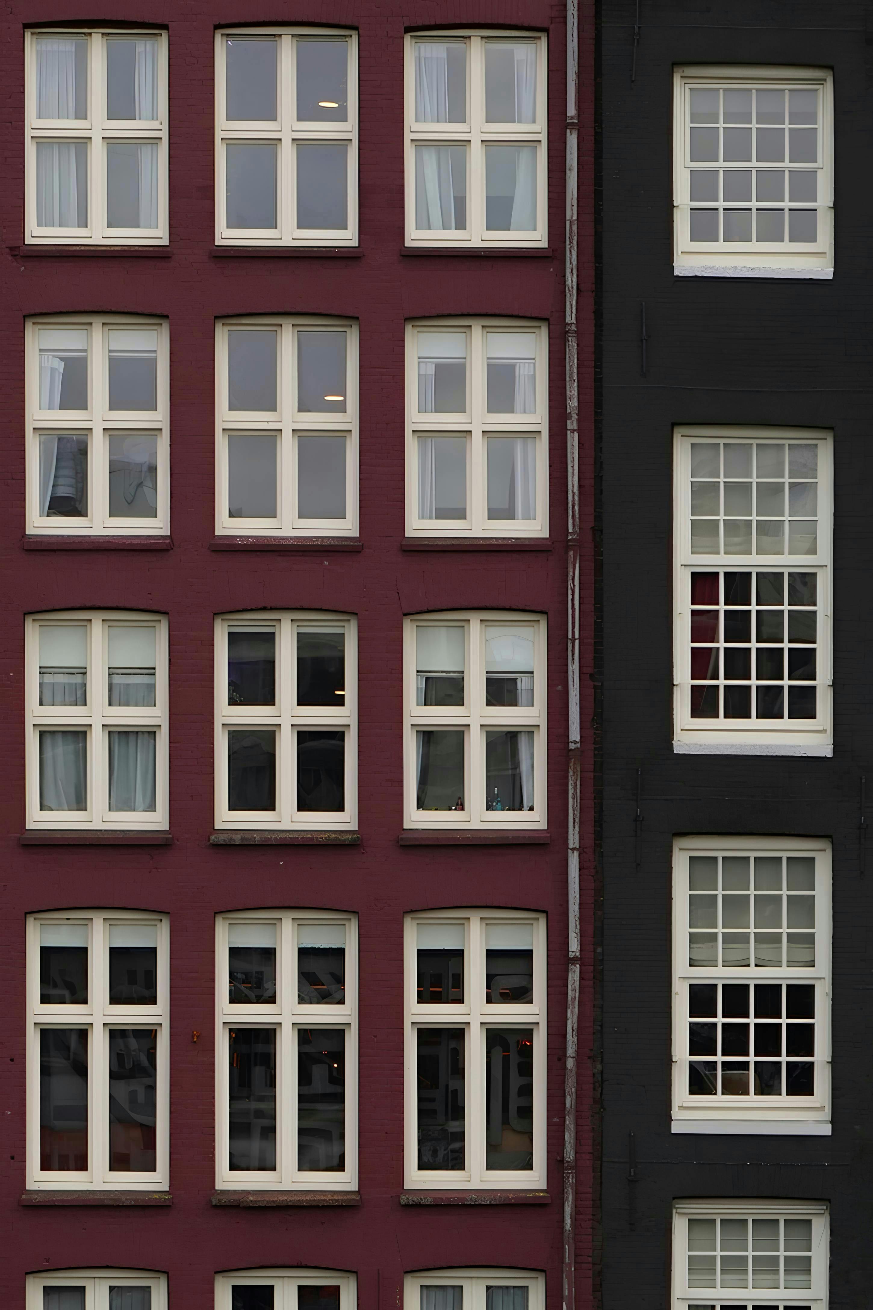 A cityscape showing symmetrical red and black building facades with multiple windows.