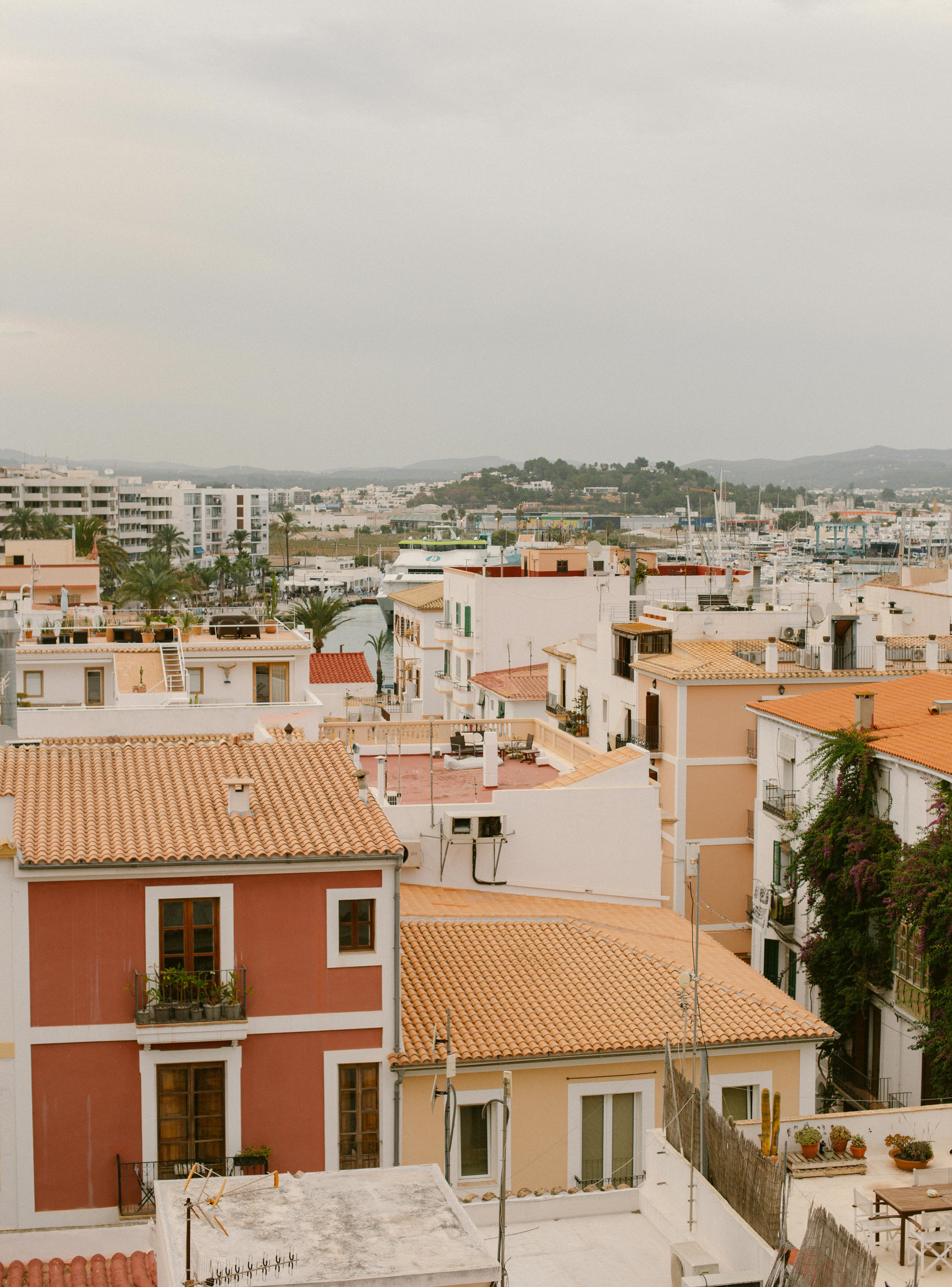 A picturesque view of tiled rooftops in Ibiza, highlighting traditional architecture and vibrant Mediterranean colors.