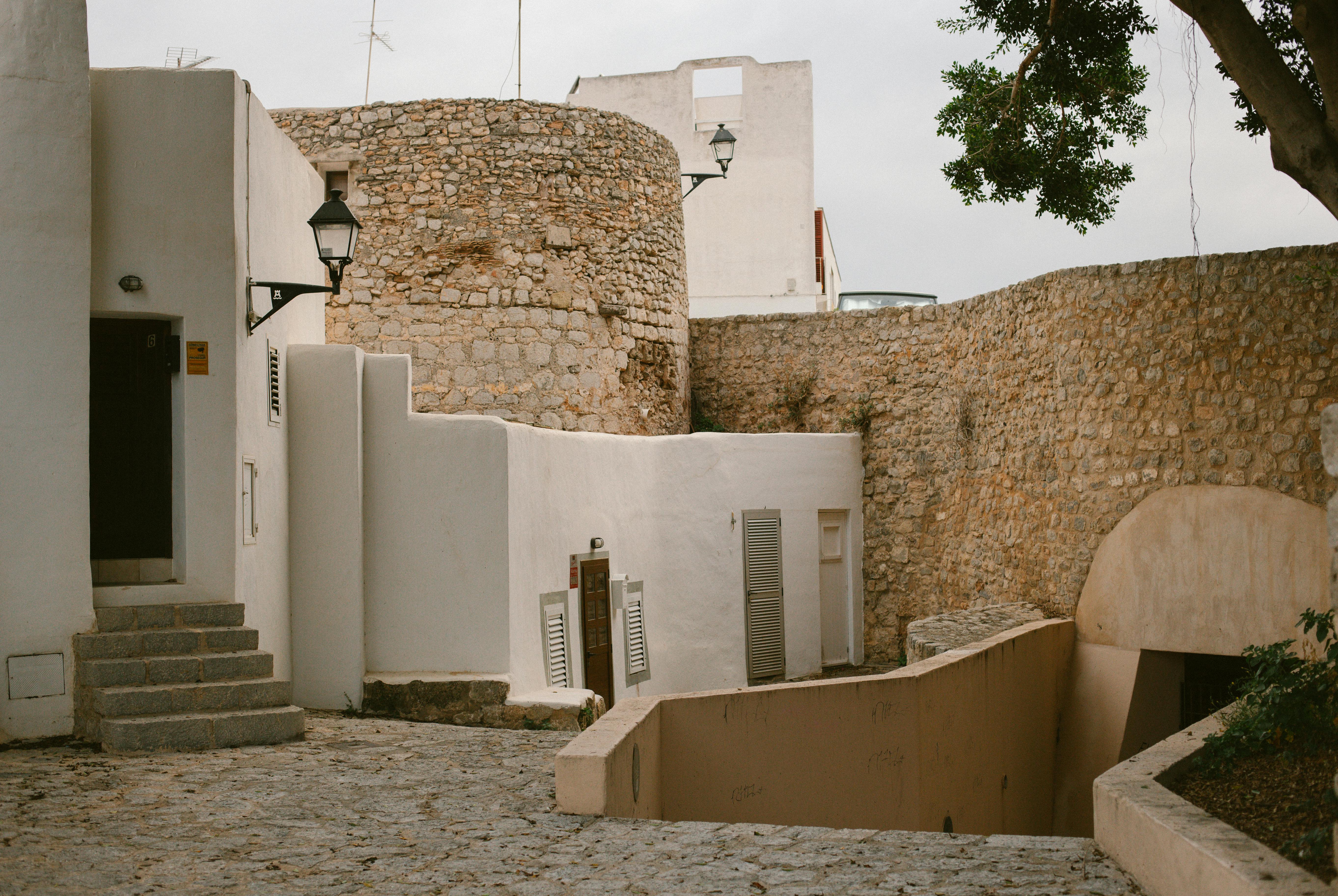 Explore the rustic stone architecture of quaint alleys in Ibiza's historic district.