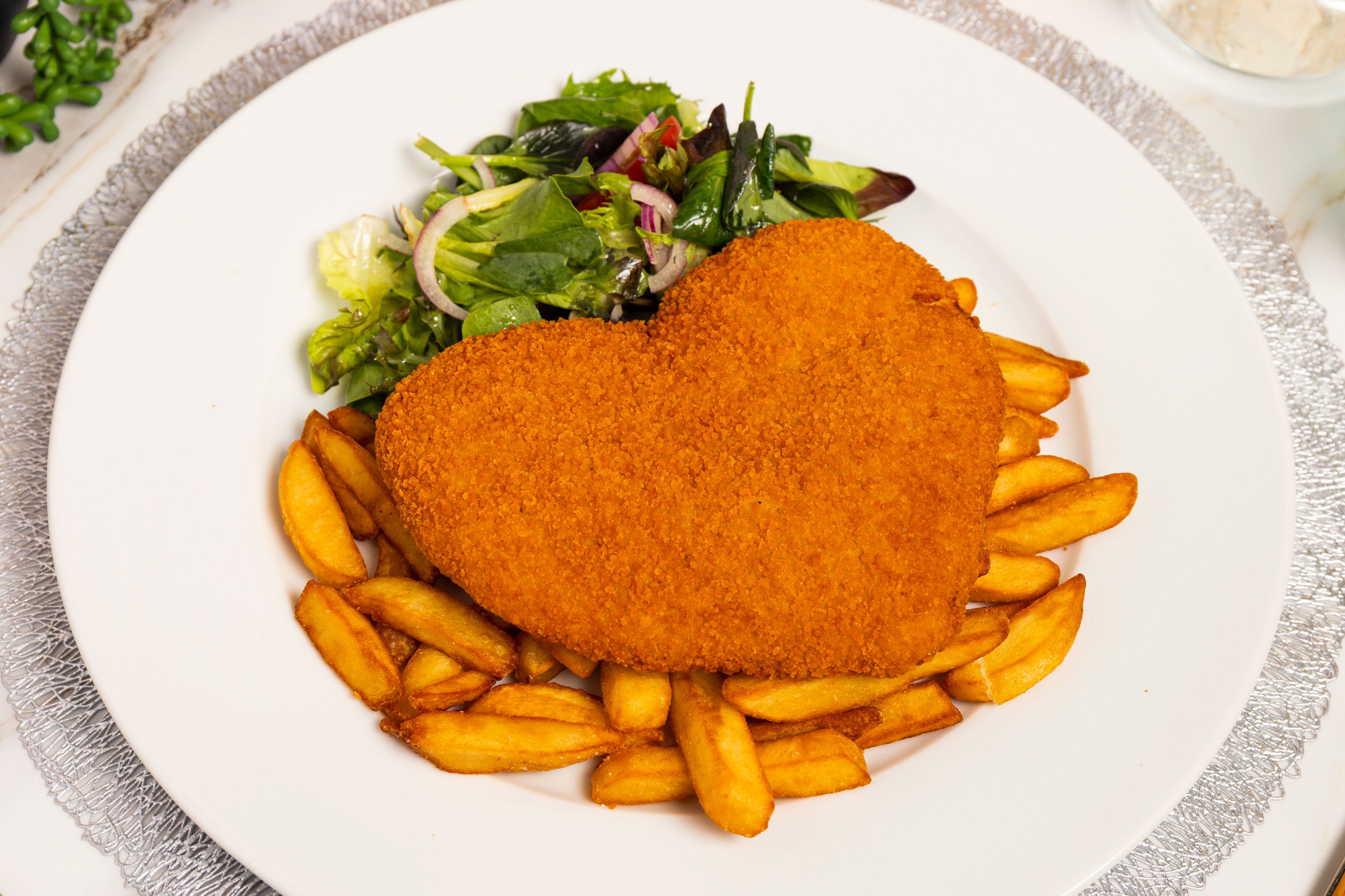 Chicken schnitzel served with chips and garden salad