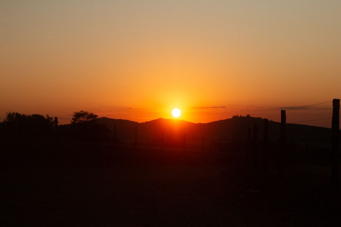 Beautiful Sunset Over Rolling Hills Landscape · Free Stock Photo