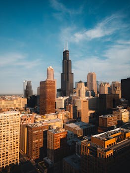 Aerial view of the Chicago skyline featuring the Willis Tower under a clear blue sky.