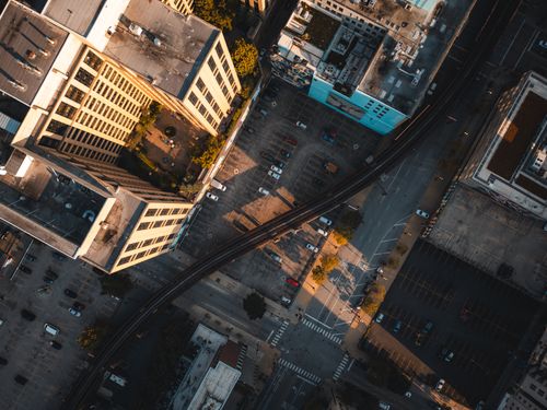 Free Aerial view of cityscape featuring buildings, streets, and rail tracks at dusk. Stock Photo