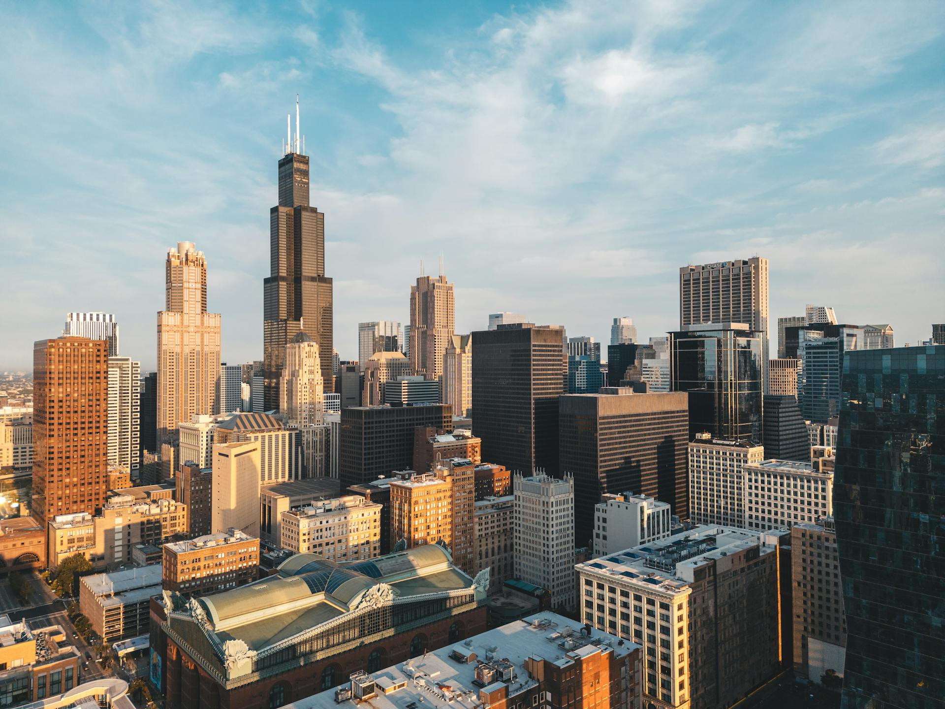 Aerial view of Chicago skyline with Willis Tower under a blue sky, vibrant urban landscape.