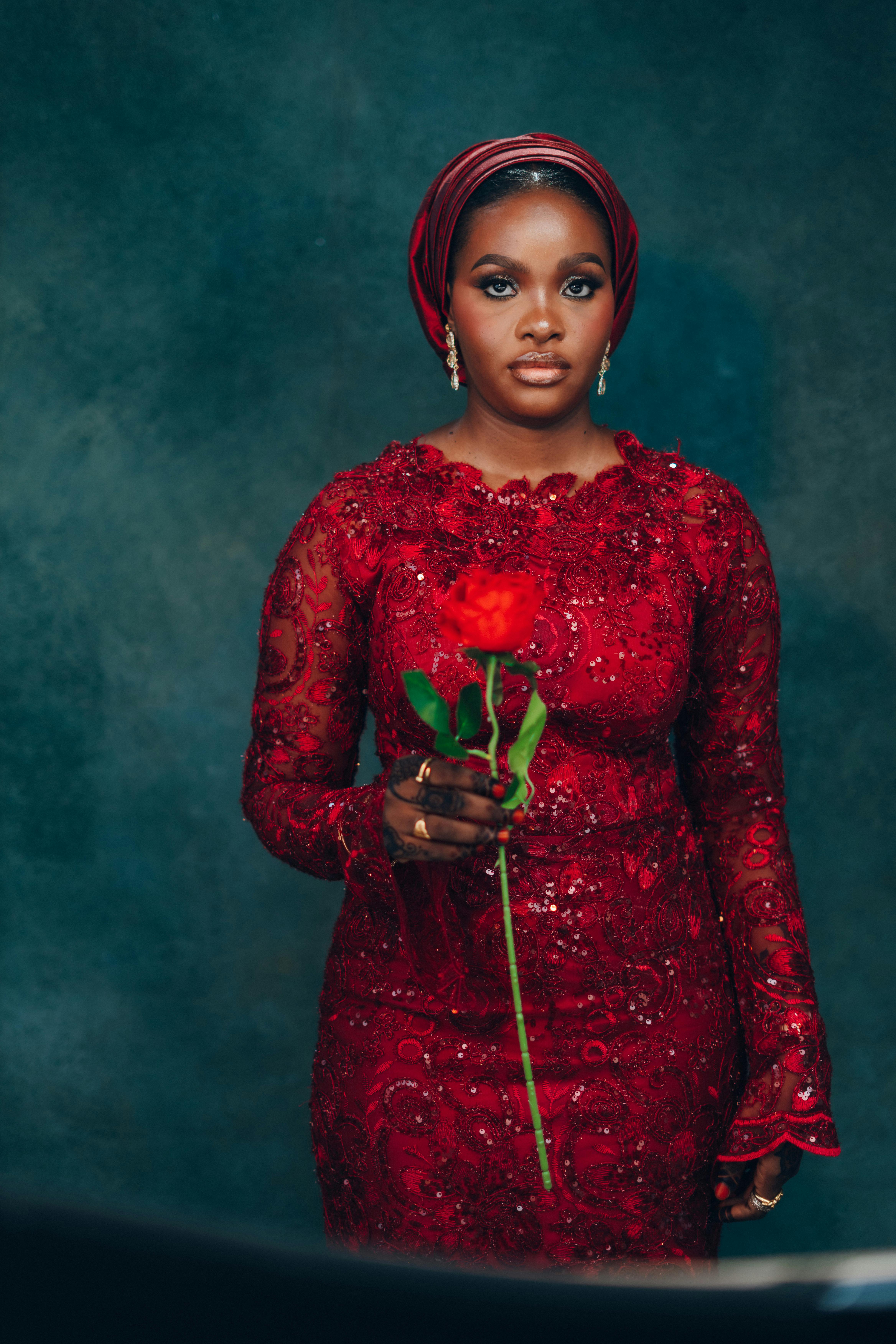 Beautiful Nigerian bride in red lace dress holding a rose — Darkshade Photos on Pexels