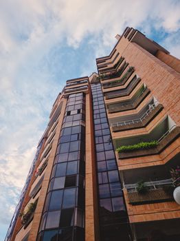Low-angle shot of a modern high-rise building with balconies and glazed windows in Bucaramanga, Colombia.