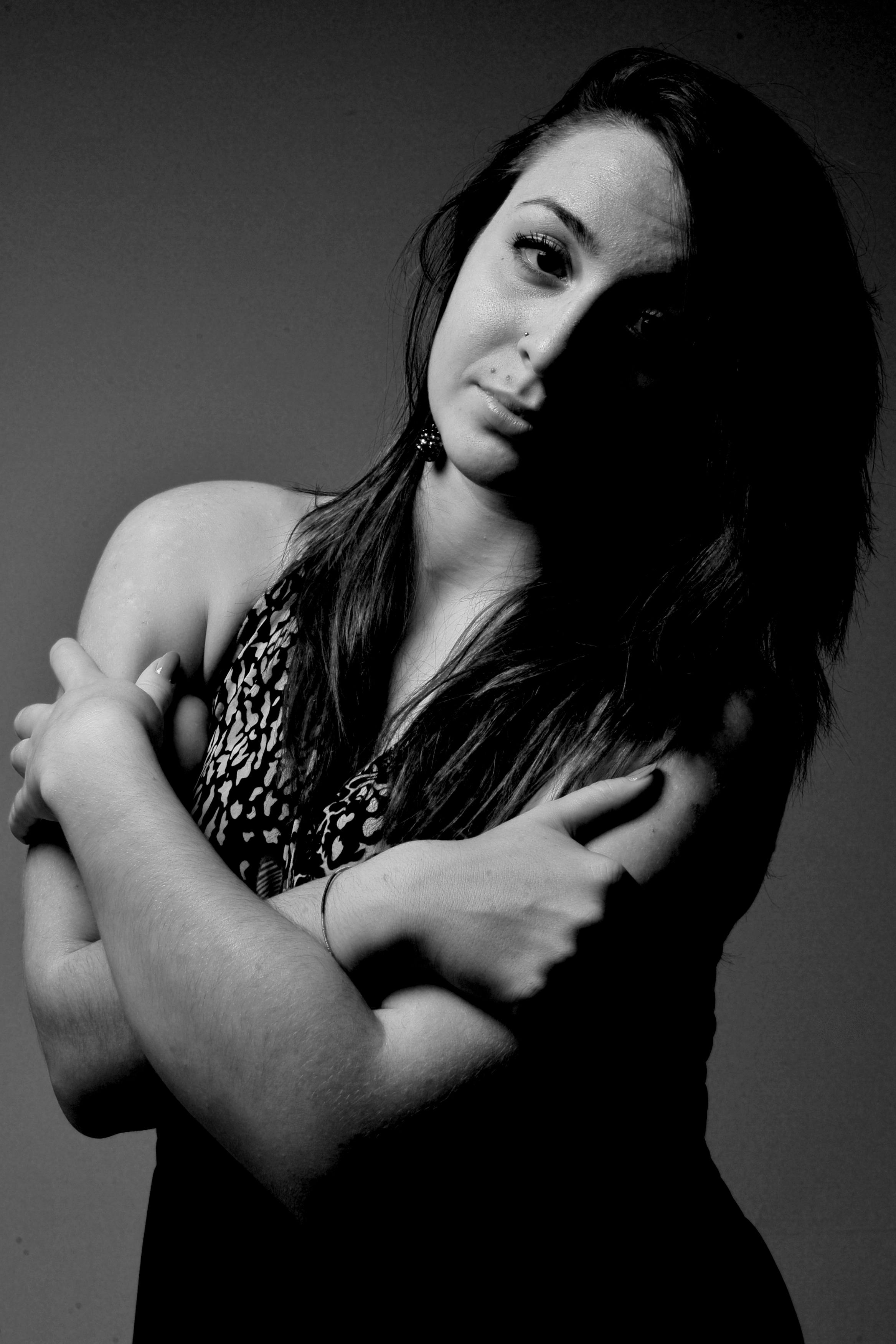 Artistic black and white portrait of a woman partially in shadows, creating a mysterious atmosphere.