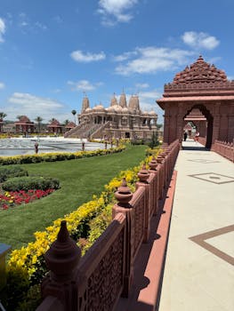 Stunning view of a Hindu temple surrounded by lush gardens under a clear blue sky.