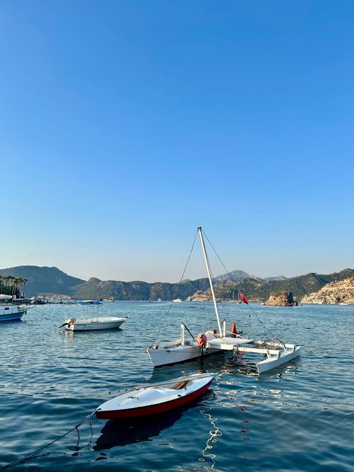 Free Calm bay with small boats docked, surrounded by hills under a clear blue sky. Stock Photo