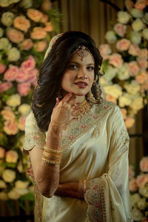 Free A beautiful bride poses in traditional attire, surrounded by vibrant flowers, exuding elegance and grace. Stock Photo