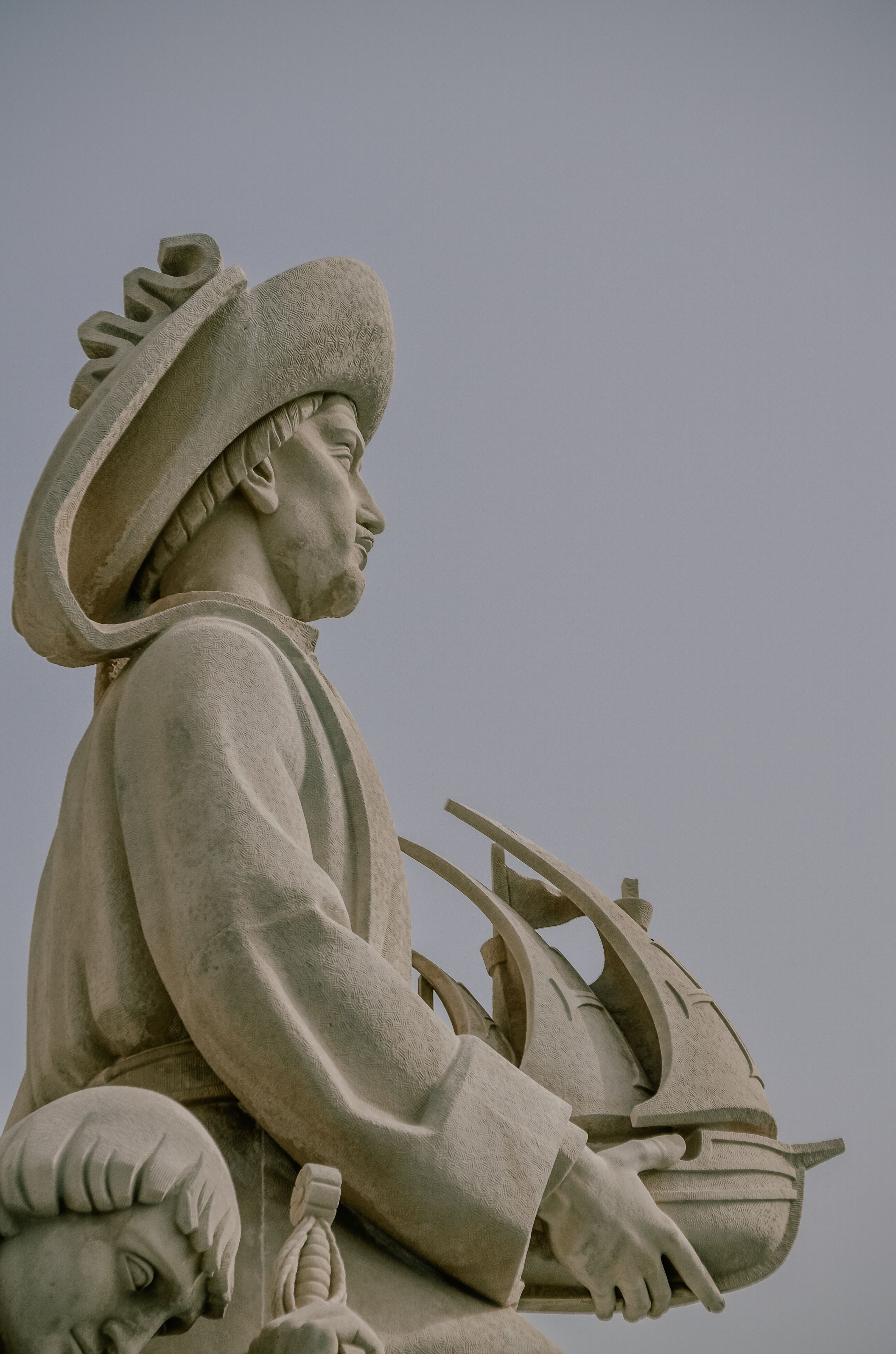 Side view of explorer statue holding ship at Monument to the Discoveries, Lisbon.