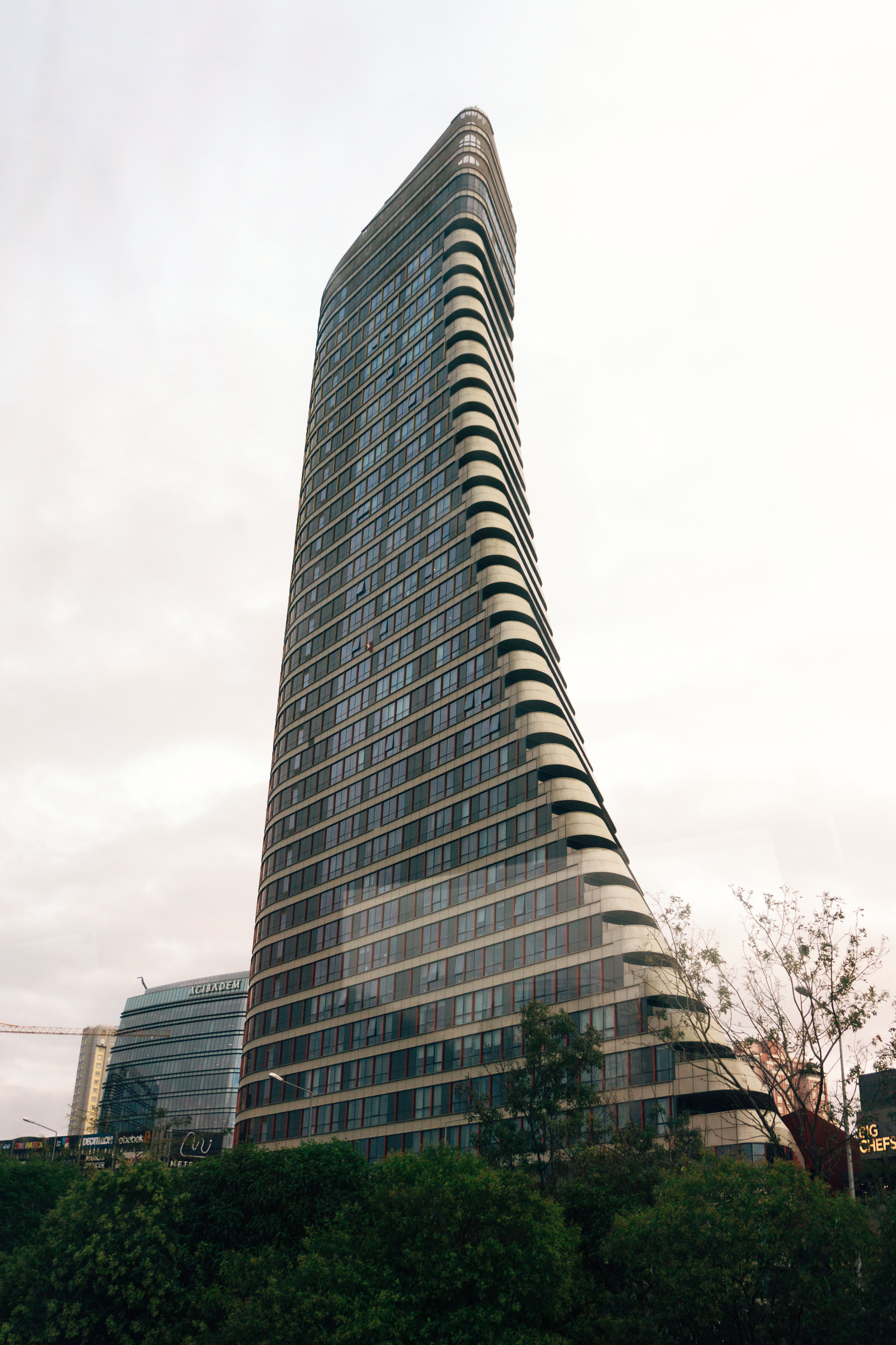 Modern Curved Skyscraper in Urban Setting · Free Stock Photo