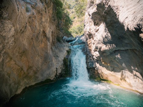 Beautiful waterfall cascading through rocky cliffs in Khyber Pakhtunkhwa, Pakistan, surrounded by lush greenery.