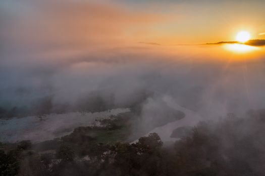 Captivating aerial view of sunrise over a misty river in Tell, Wisconsin.