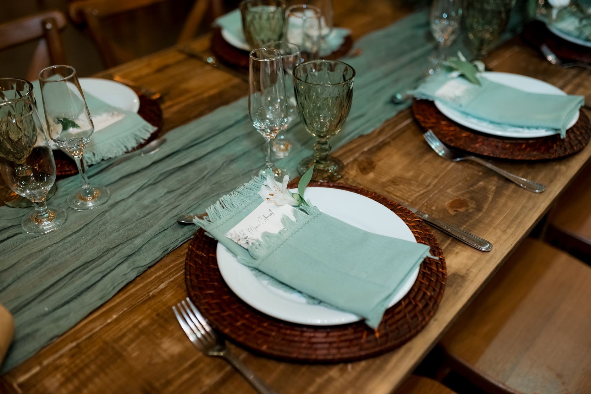 Beautifully set table with teal accents and rustic wooden elements.