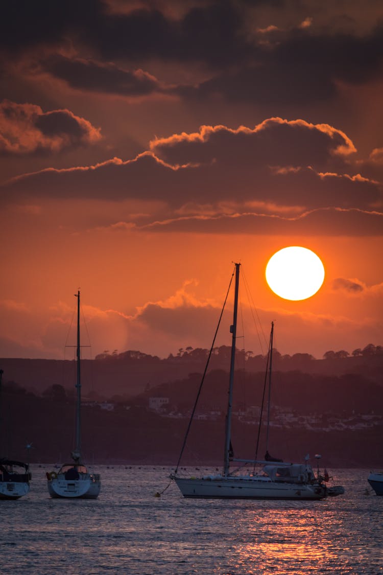 Boats Sailing On Sea During Sunset