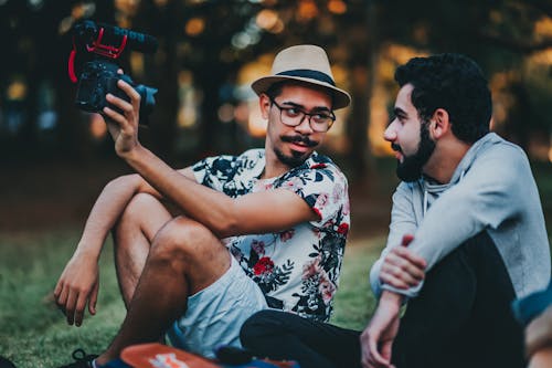 Man Holding Camera Beside Another Man