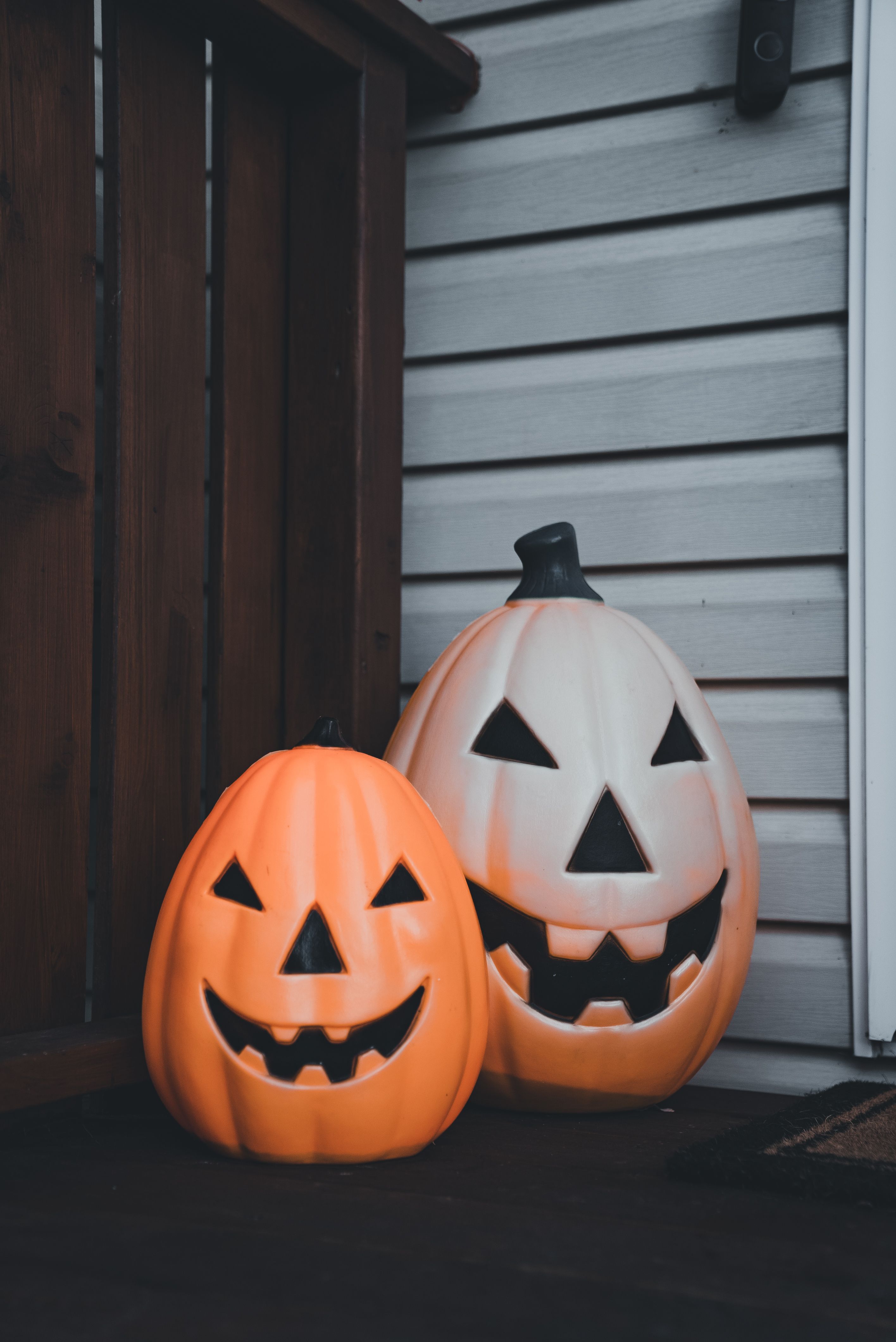Two Halloween jack-o'-lanterns placed on a porch, creating a spooky atmosphere.