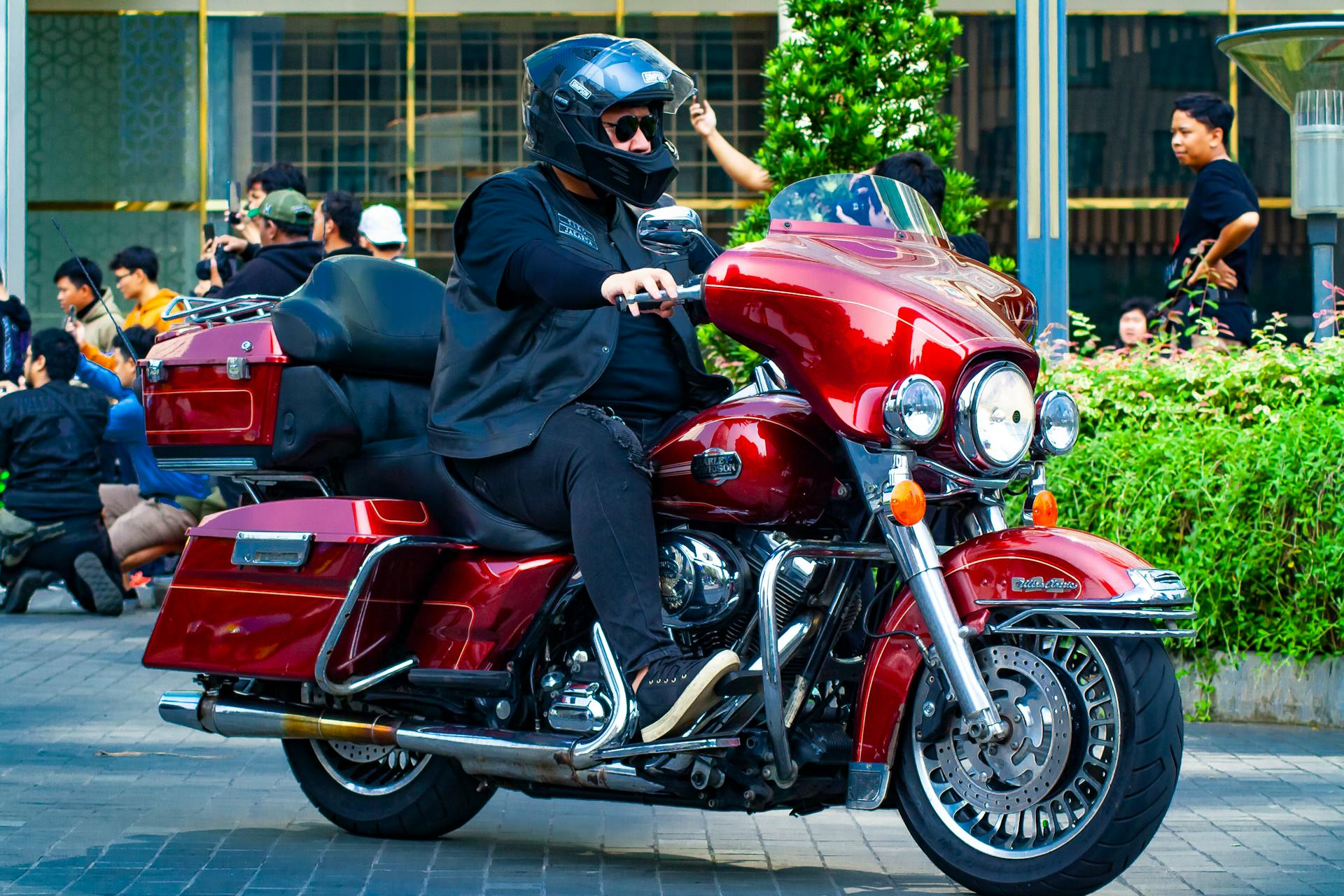 A biker on a Harley Davidson Ultra CVO riding through city streets in Indonesia.