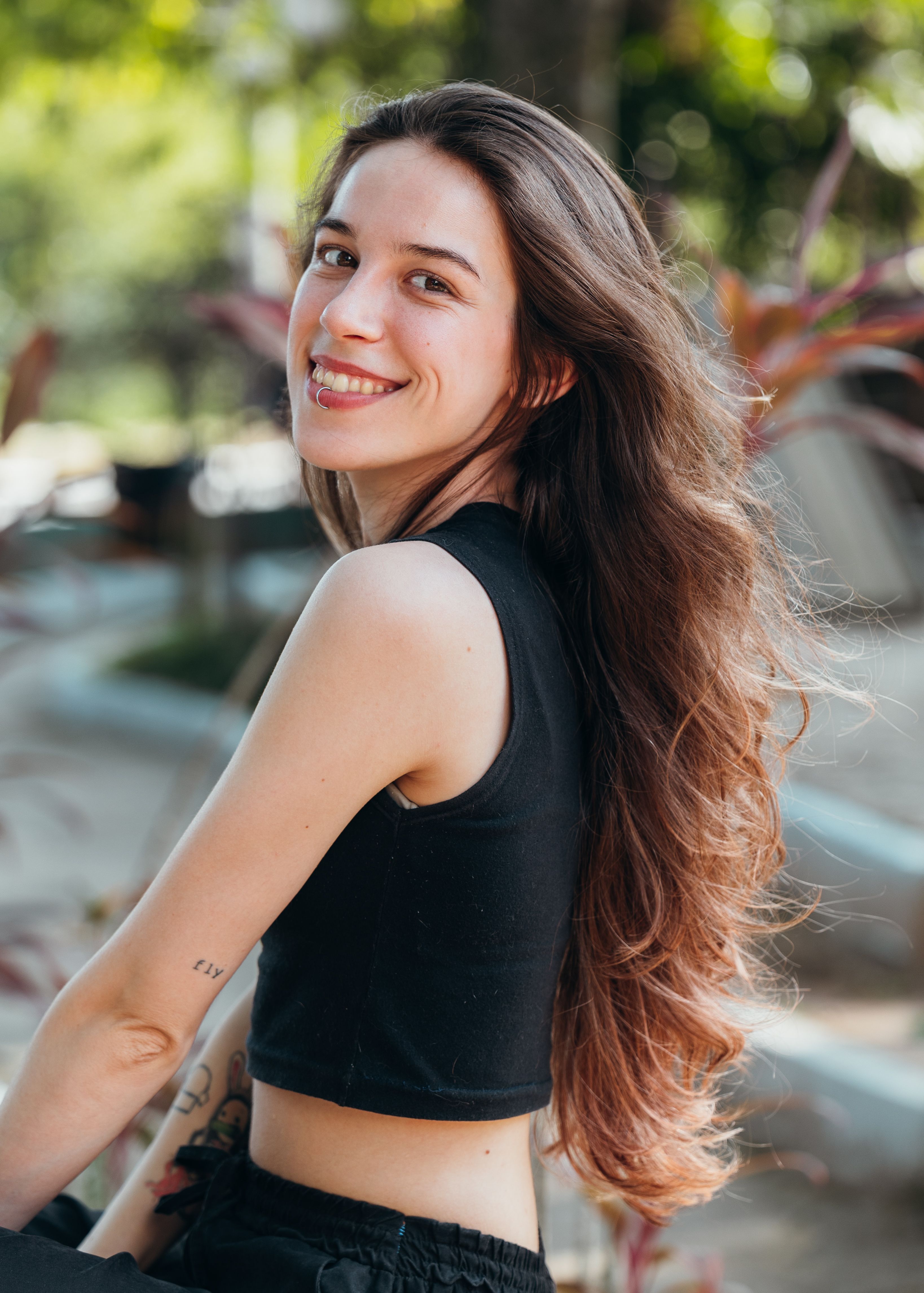 Cheerful woman with long hair enjoying a sunny day outdoors.