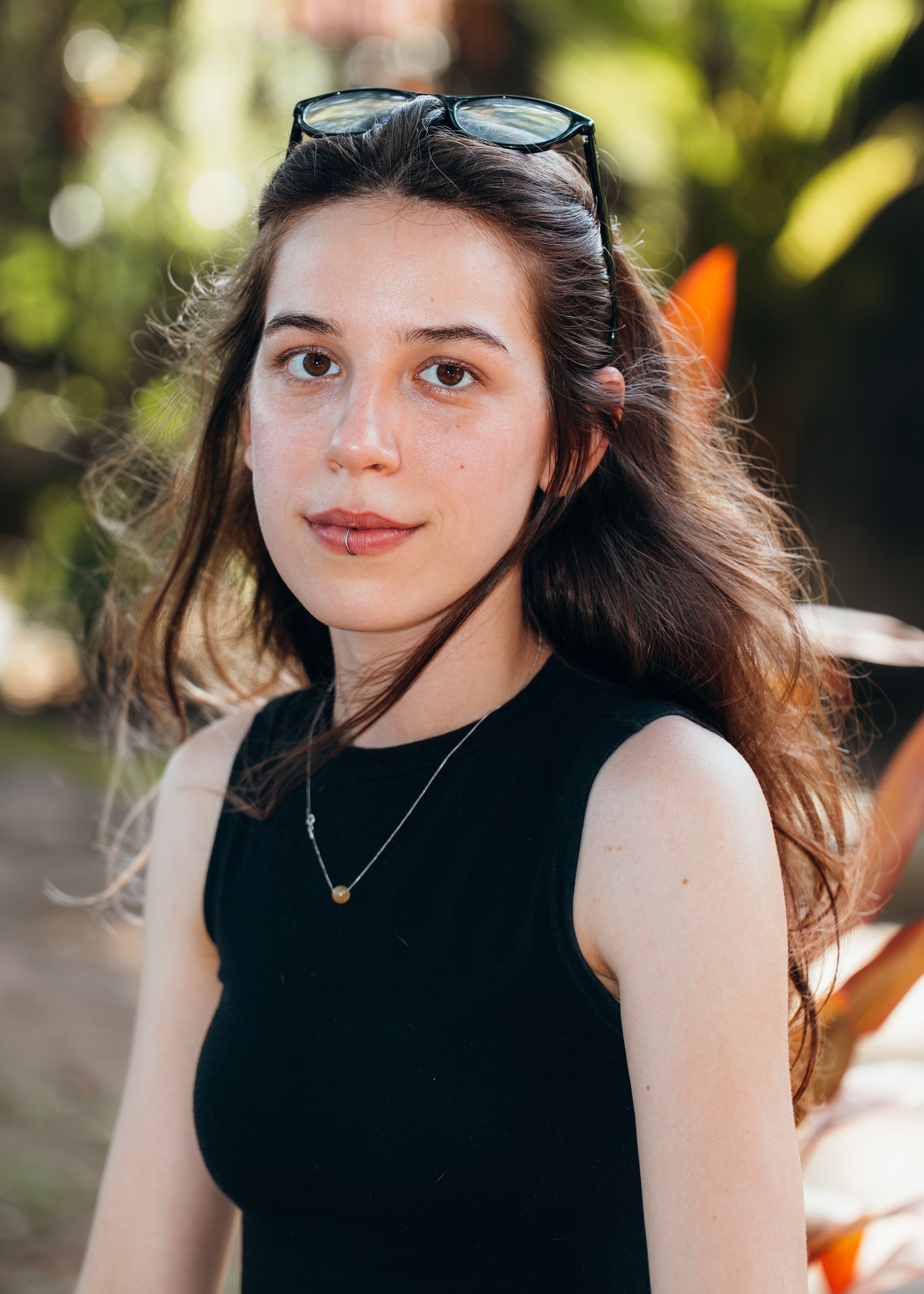 Close-up portrait of a young woman outdoors with a serene expression.