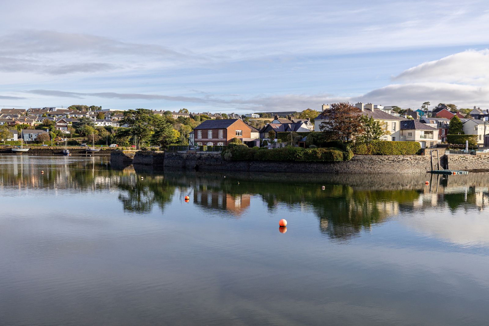 Houses reflect in the calm waters of Kinsale, County Cork, Ireland