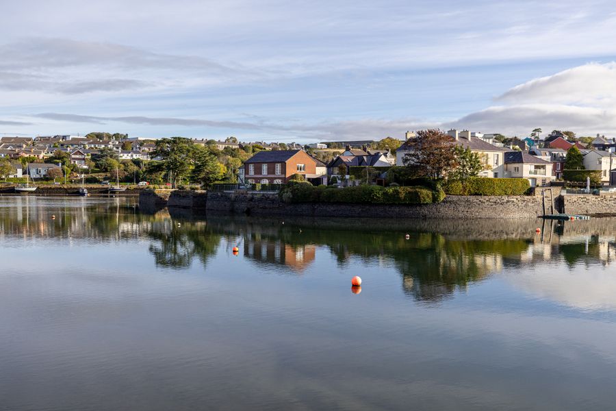 Houses reflect in the calm waters of Kinsale, County Cork, Ireland