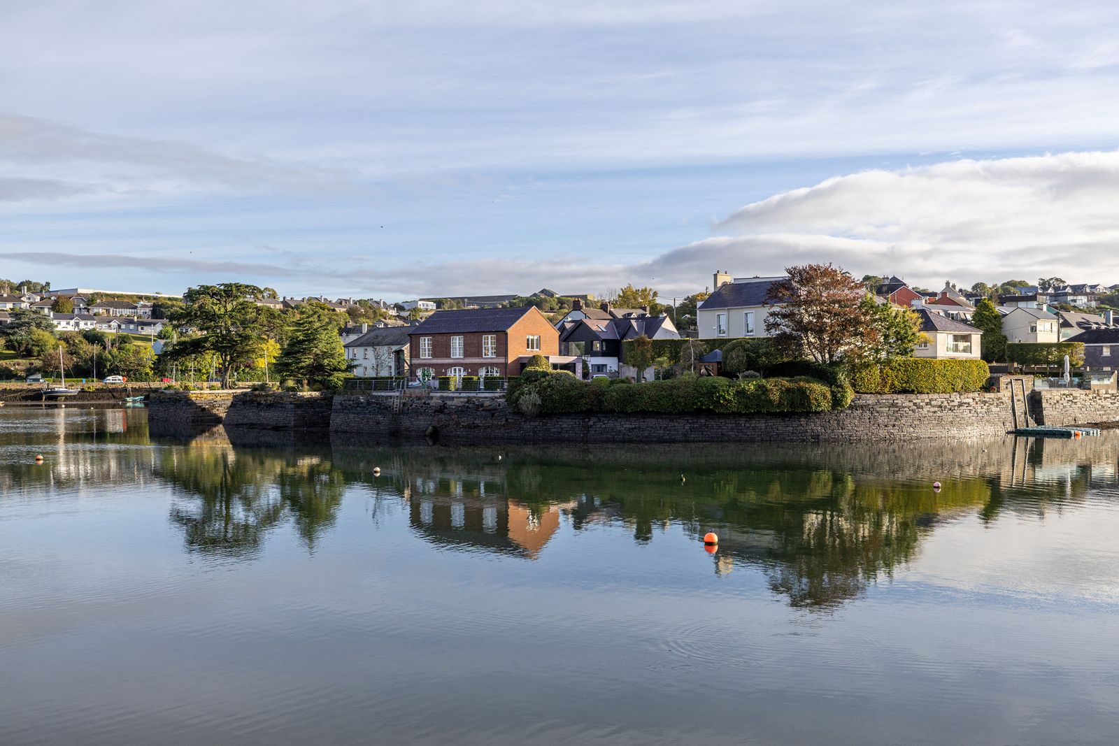 Waterfront houses reflected on calm water in Kinsale, County Cork, Ireland